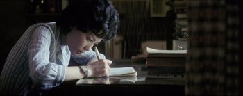 Movie still from “2046” (2004), directed by Kar-Wai Wong – A person writing on a piece of paper on top of a table; Close Up shot, High angle