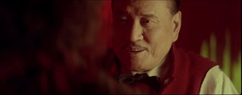Movie still from “2046” (2004), directed by Kar-Wai Wong – An older man wearing a bow tie looking at the camera; Close Up shot, Over the shoulder angle