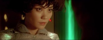 Movie still from “2046” (2004), directed by Kar-Wai Wong – A person with a red earring; Close Up shot, High angle