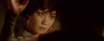 Movie still from “2046” (2004), directed by Kar-Wai Wong – A person wearing a red earring; Close Up shot, Over the shoulder angle