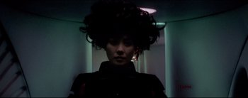 Movie still from “2046” (2004), directed by Kar-Wai Wong – A woman with a black wig in a dark room; Close Up shot, Low angle