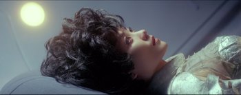 Movie still from “2046” (2004), directed by Kar-Wai Wong – A young woman with long black hair laying on a bed; Close Up shot, Overhead angle