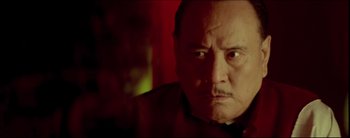 Movie still from “2046” (2004), directed by Kar-Wai Wong – An older man with a serious look on his face; Close Up shot, Low angle