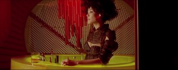 Movie still from “2046” (2004), directed by Kar-Wai Wong – A woman sitting at a table in front of red candles; Medium shot, Low angle