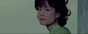 Movie still from “2046” (2004), directed by Kar-Wai Wong – A person wearing a green shirt; Close Up shot, Low angle