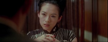 Movie still from “2046” (2004), directed by Kar-Wai Wong – A young woman with a black and white striped shirt; Close Up shot, Over the shoulder angle