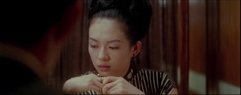 Movie still from “2046” (2004), directed by Kar-Wai Wong – A young woman holding a ring in her hand; Close Up shot, Over the shoulder angle