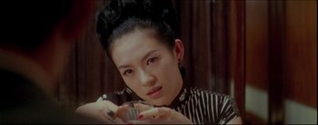Movie still from “2046” (2004), directed by Kar-Wai Wong – A young woman holding a glass of water; Close Up shot, Over the shoulder angle