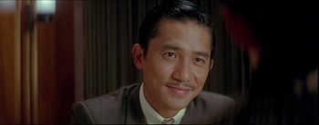 Movie still from “2046” (2004), directed by Kar-Wai Wong – A person wearing a suit and tie; Close Up shot, Low angle