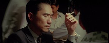 Movie still from “2046” (2004), directed by Kar-Wai Wong – A person smoking a cigarette; Close Up shot, Over the shoulder angle