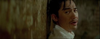 Movie still from “2046” (2004), directed by Kar-Wai Wong – A person leaning against a wall; Close Up shot, Low angle