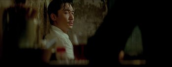 Movie still from “2046” (2004), directed by Kar-Wai Wong – A man sitting in front of a table with wine glasses on it; Close Up shot, Over the shoulder angle