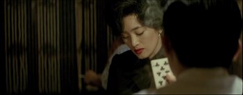 Movie still from “2046” (2004), directed by Kar-Wai Wong – A woman is holding a deck of playing cards; Close Up shot, Over the shoulder angle
