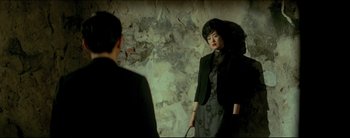 Movie still from “2046” (2004), directed by Kar-Wai Wong – A man and a woman are standing in front of a mirror; Medium shot, Over the shoulder angle
