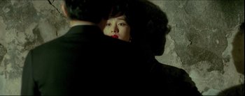 Movie still from “2046” (2004), directed by Kar-Wai Wong – A woman with red lipstick is hugging a man; Medium shot, High angle