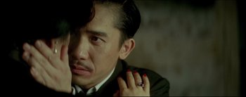 Movie still from “2046” (2004), directed by Kar-Wai Wong – A person wearing a suit and tie; Close Up shot, Over the shoulder angle