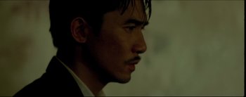 Movie still from “2046” (2004), directed by Kar-Wai Wong – A person wearing a suit and tie; Close Up shot, Low angle