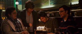 Movie still from “21” (2008), directed by Robert Luketic – A man and a woman sitting in front of a cake; Medium shot, Over the shoulder angle