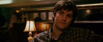 Movie still from “21” (2008), directed by Robert Luketic – A man sitting in front of a lamp in a room; Close Up shot, Over the shoulder angle