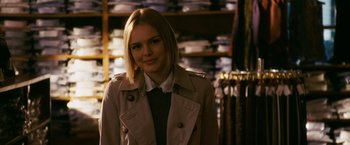 Movie still from “21” (2008), directed by Robert Luketic – A woman in a trench coat standing in a store; Medium shot, Over the shoulder angle