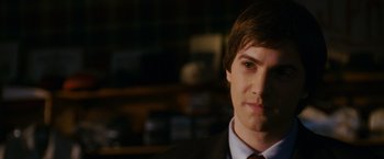 Movie still from “21” (2008), directed by Robert Luketic – A man in a suit and tie looking at the camera; Close Up shot, Over the shoulder angle