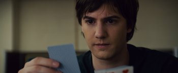 Movie still from “21” (2008), directed by Robert Luketic – A young man holding a card in front of his face; Close Up shot, Over the shoulder angle