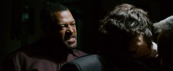 Movie still from “21” (2008), directed by Robert Luketic – A man is talking to another man in a dark room; Close Up shot, Over the shoulder angle