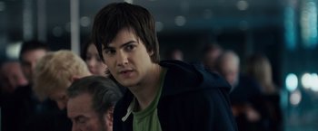 Movie still from “21” (2008), directed by Robert Luketic – A young man with brown hair and a green t - shirt; Close Up shot, Over the shoulder angle