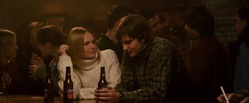 Movie still from “21” (2008), directed by Robert Luketic – A man and a woman sitting at a table with a bottle of beer; Medium shot, Over the shoulder angle