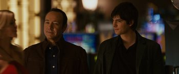 Movie still from “21” (2008), directed by Robert Luketic – Two men standing next to each other in a dark room; Close Up shot, Over the shoulder angle