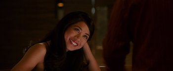 Movie still from “21” (2008), directed by Robert Luketic – A woman smiles brightly while sitting at a table; Close Up shot, Over the shoulder angle