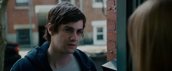 Movie still from “21” (2008), directed by Robert Luketic – A young man is standing in front of a brick wall; Close Up shot, Over the shoulder angle