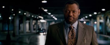 Movie still from “21” (2008), directed by Robert Luketic – A man wearing a suit and tie in a parking garage; Close Up shot, Over the shoulder angle