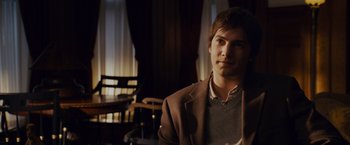 Movie still from “21” (2008), directed by Robert Luketic – A man in a brown jacket is sitting at a table; Close Up shot, Over the shoulder angle