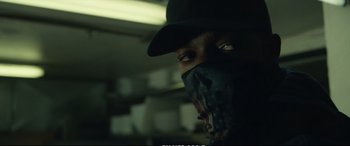 Movie still from “21 Bridges” (2019), directed by Brian Kirk – A man wearing a black hat and a black mask; Close Up shot, Low angle