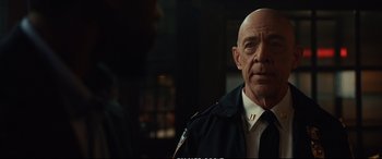 Movie still from “21 Bridges” (2019), directed by Brian Kirk – A man in a police uniform is looking at the camera; Close Up shot, Over the shoulder angle