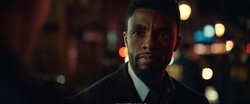 Movie still from “21 Bridges” (2019), directed by Brian Kirk – A person wearing a suit and tie; Close Up shot, Low angle