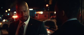 Movie still from “21 Bridges” (2019), directed by Brian Kirk – A man wearing a suit and tie talking to another man in a suit and tie; Close Up shot, Over the shoulder angle