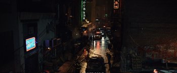 Movie still from “21 Bridges” (2019), directed by Brian Kirk – A city street at night lit by street lights; Extreme Wide shot, High angle