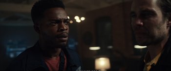 Movie still from “21 Bridges” (2019), directed by Brian Kirk – A man with a beard is looking into the distance; Close Up shot, Over the shoulder angle