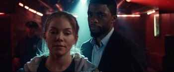 Movie still from “21 Bridges” (2019), directed by Brian Kirk – A man and a woman standing next to each other; Close Up shot, Over the shoulder angle