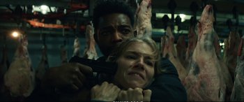 Movie still from “21 Bridges” (2019), directed by Brian Kirk – A man and a woman holding guns in a room; Close Up shot, Over the shoulder angle