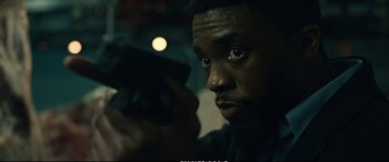 Movie still from “21 Bridges” (2019), directed by Brian Kirk – A man holding a gun in his hand; Close Up shot, Over the shoulder angle