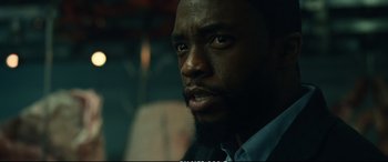 Movie still from “21 Bridges” (2019), directed by Brian Kirk – A person with a beard; Close Up shot, Low angle