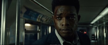 Movie still from “21 Bridges” (2019), directed by Brian Kirk – A person on a train; Close Up shot, Over the shoulder angle