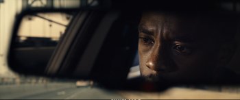 Movie still from “21 Bridges” (2019), directed by Brian Kirk – A man's face in a car mirror; Extreme Close Up shot, Over the shoulder angle