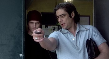 Movie still from “21 Grams” (2003), directed by Alejandro G. Iñárritu – A man holding a cell phone in front of another man; Medium shot, Over the shoulder angle