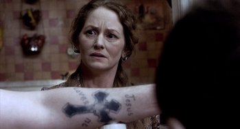 Movie still from “21 Grams” (2003), directed by Alejandro G. Iñárritu – A woman with a cross tattooed on her arm; Close Up shot, Over the shoulder angle