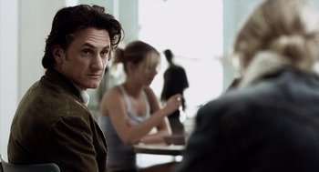 Movie still from “21 Grams” (2003), directed by Alejandro G. Iñárritu – A man sitting in front of two other people; Close Up shot, Over the shoulder angle