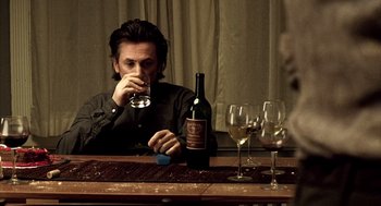 Movie still from “21 Grams” (2003), directed by Alejandro G. Iñárritu – A man sitting at a table drinking wine; Medium shot, Over the shoulder angle